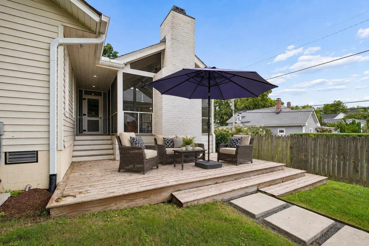 Back deck with outdoor seating and an umbrella beside the screened porch at 1001 Caldwell Ave in 12 South Nashville