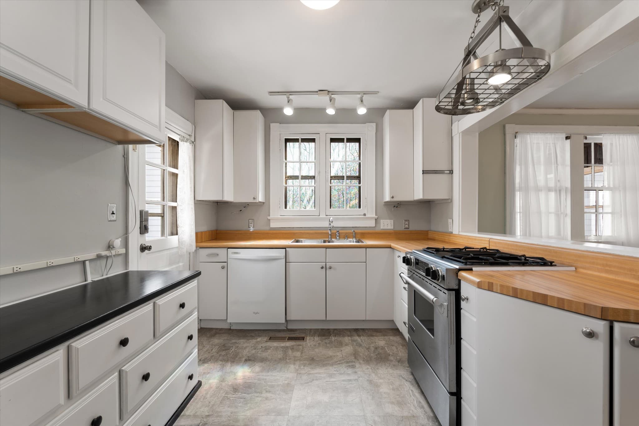 Updated kitchen with white cabinets, butcher block counters and a gas range at 1202 Ashwood Ave in 12 South Nashville