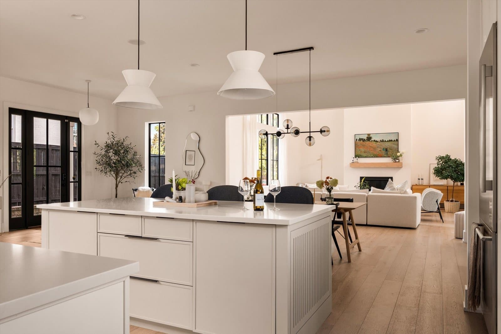 Kitchen with a white island, pendant lights and an open view to the great room at 1207 Sweetbriar Ave in 12 South Nashville