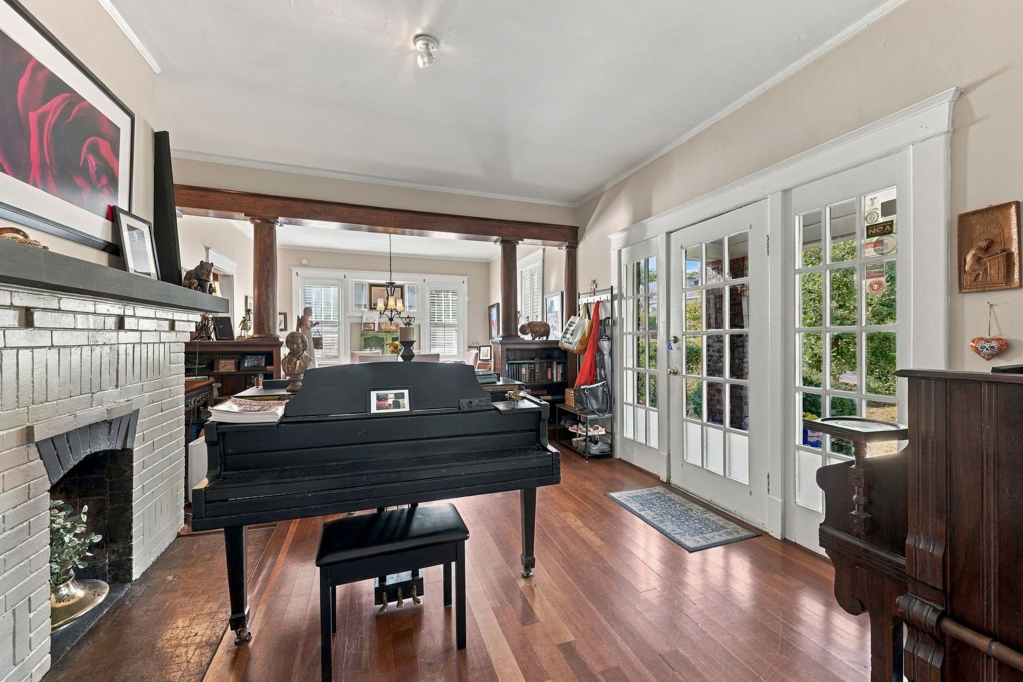 Parlor with a brick fireplace, tall ceilings, hardwood floors, and French doors at 1407 Elmwood Ave in 12 South Nashville