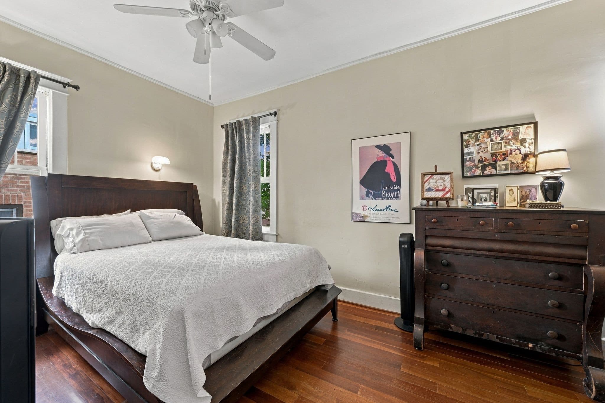 Main floor primary bedroom with hardwood floors, a ceiling fan, and two windows at 1407 Elmwood Ave in 12 South Nashville