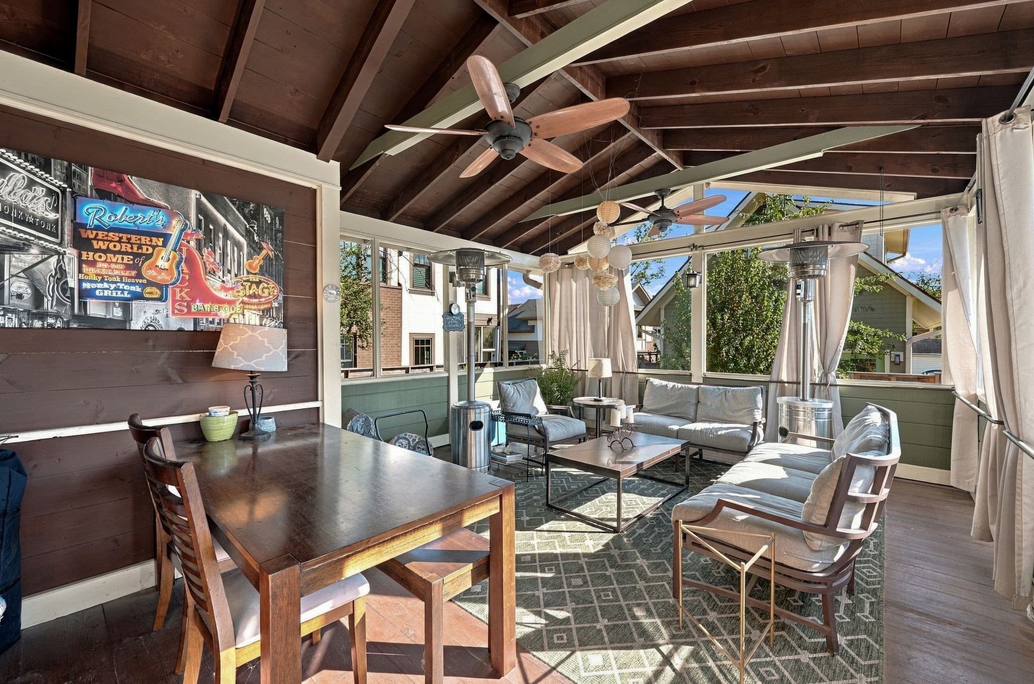 Screened deck with a wood beamed ceiling, ceiling fans, a dining table, and lounge seating at 1407 Elmwood Ave in 12 South Nashville