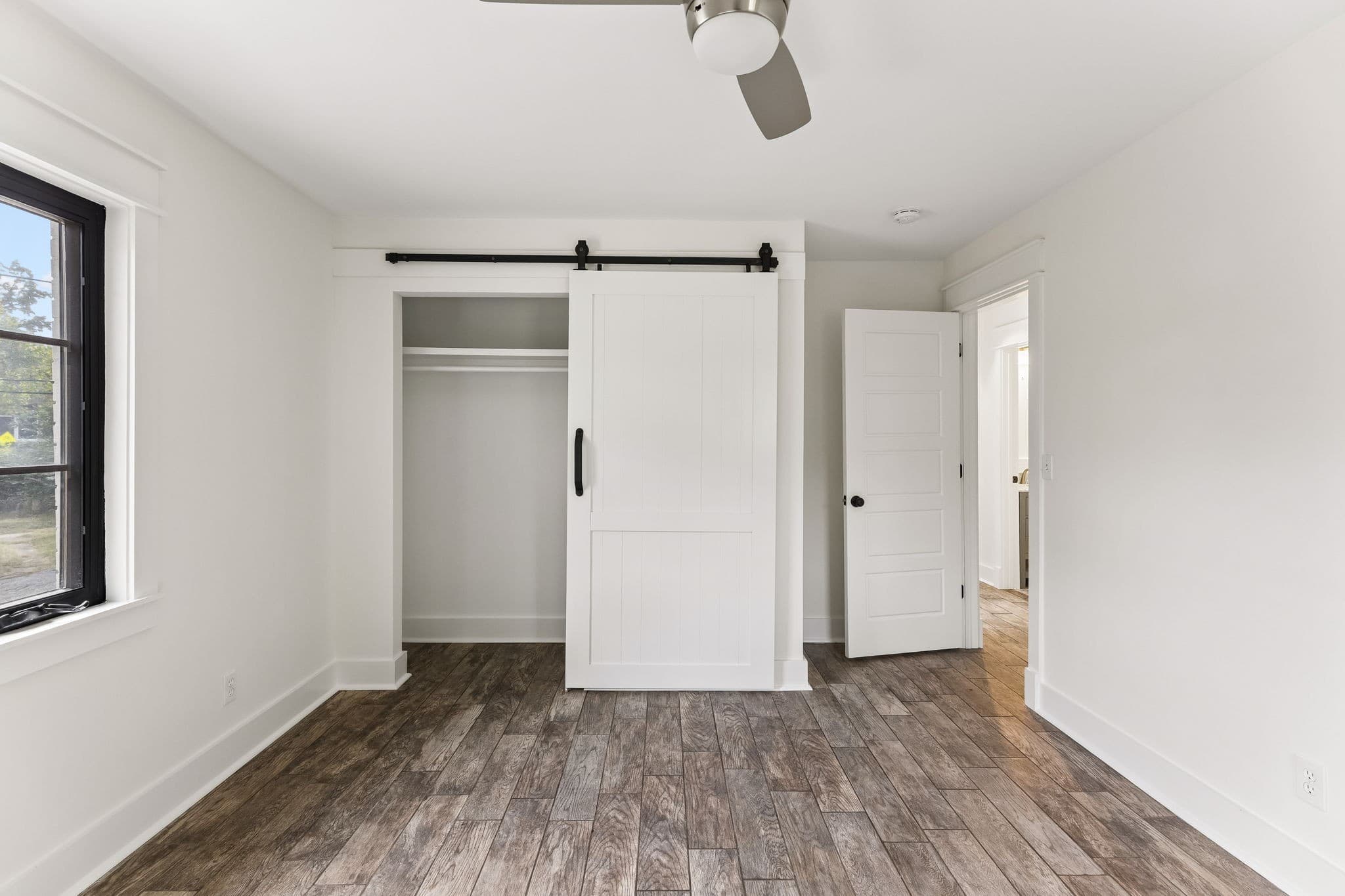 Bedroom with natural light and a sliding barn style closet door at 2028 10th Ave S in 12 South Nashville