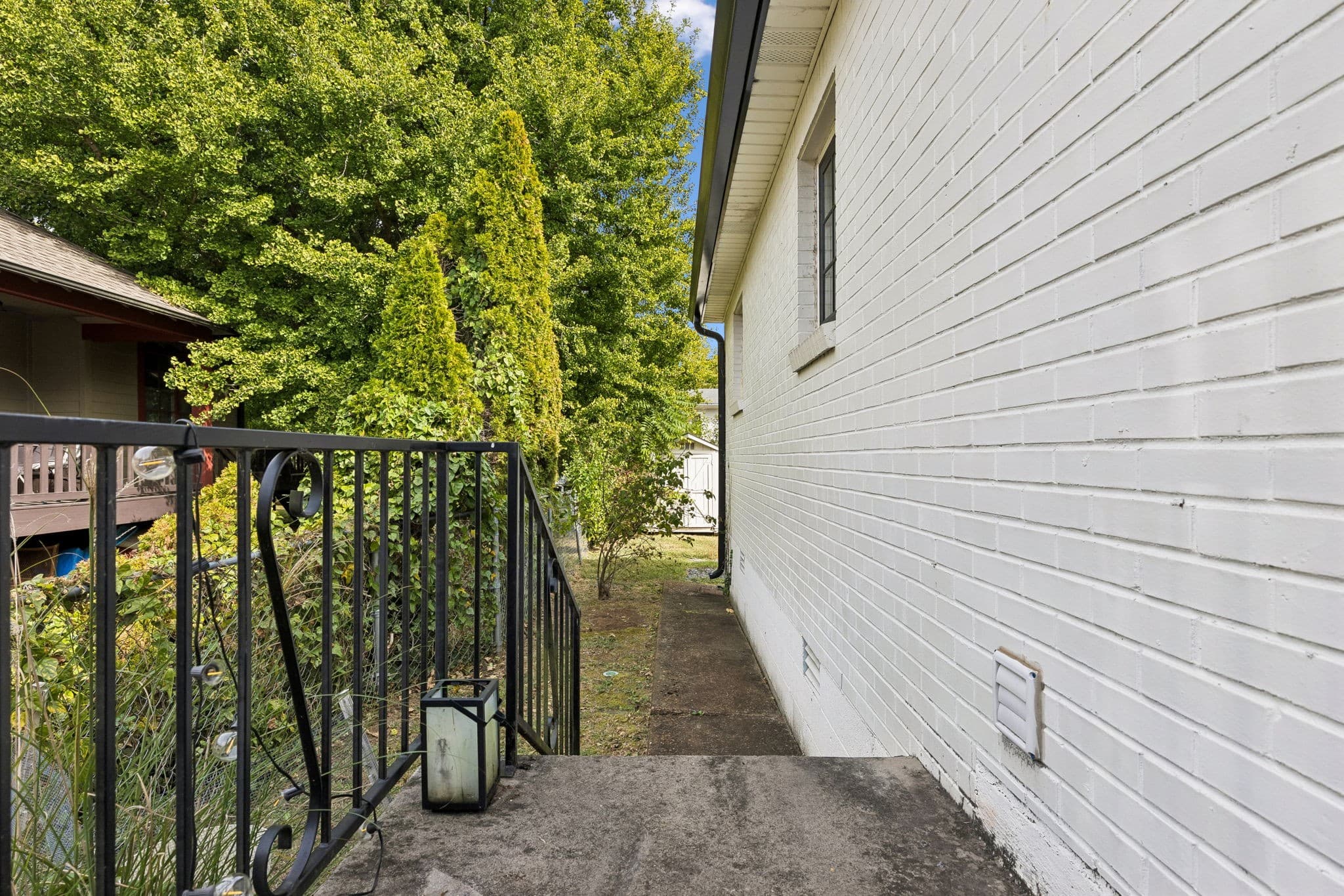 Side walkway along the white painted brick exterior leading to the back yard at 2028 10th Ave S in 12 South Nashville