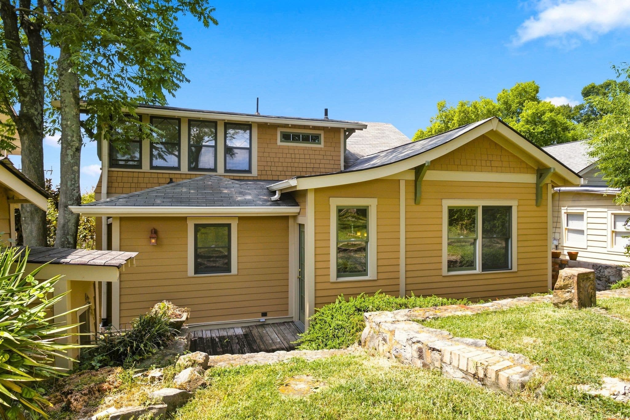Rear exterior with a wood deck, stone garden wall, and back yard at 2112 15th Ave S in 12 South Nashville