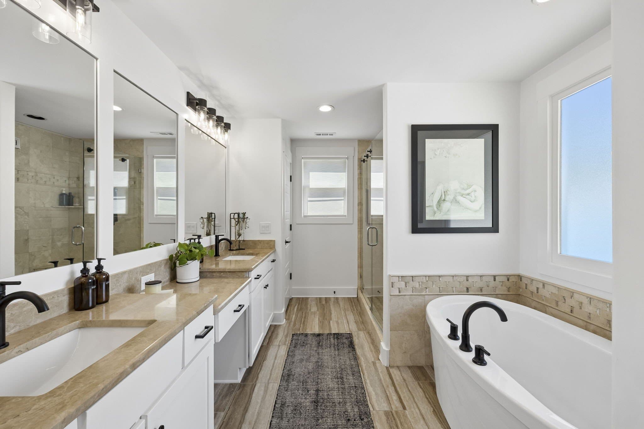 Primary bath with a double vanity, a freestanding soaking tub, a separate glass shower and matte black fixtures at 2409 Vaulx Lane in 12 South Nashville