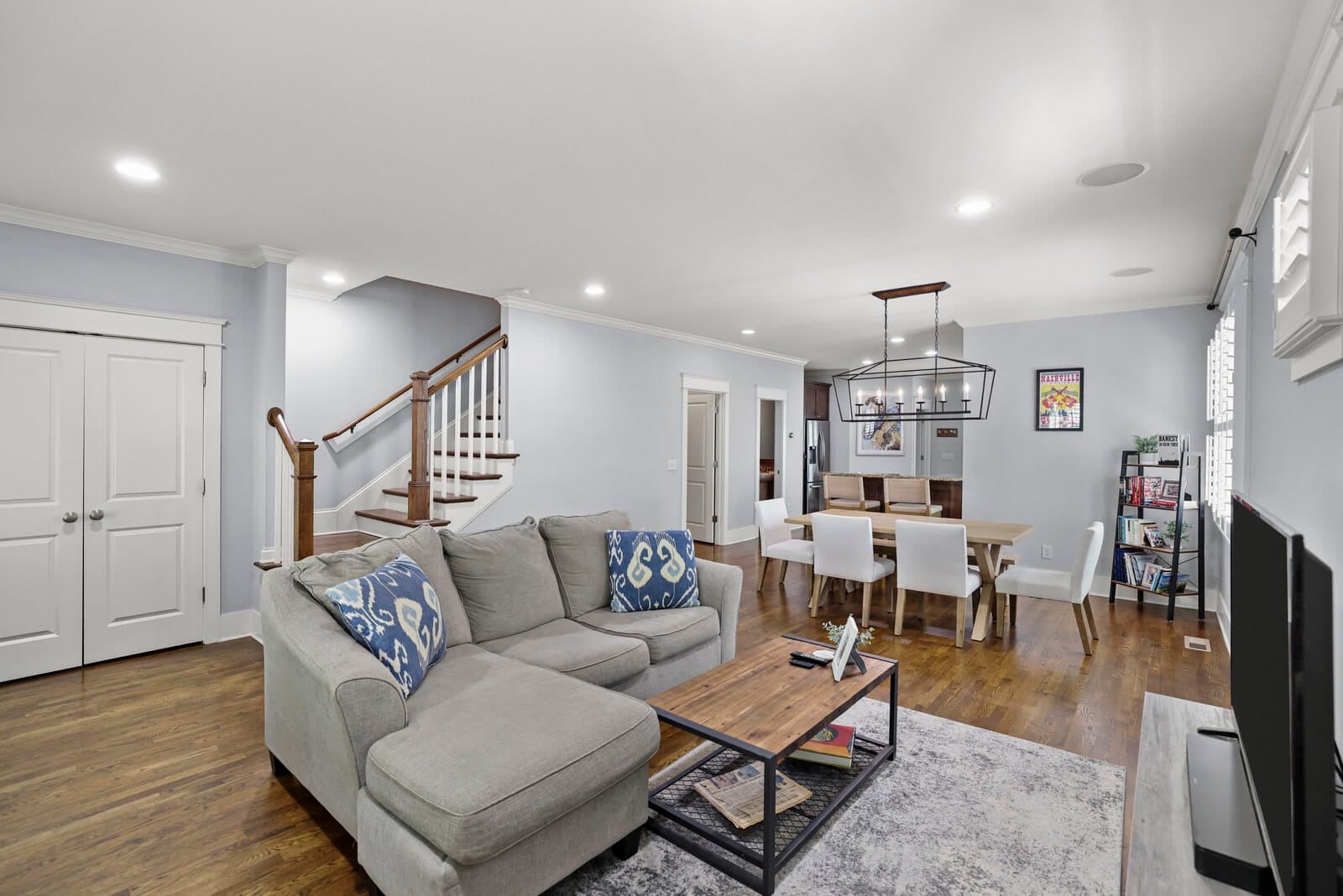 Open living room with hardwood floors, staircase and dining area beyond at 2500B 9th Ave S in 12 South Nashville