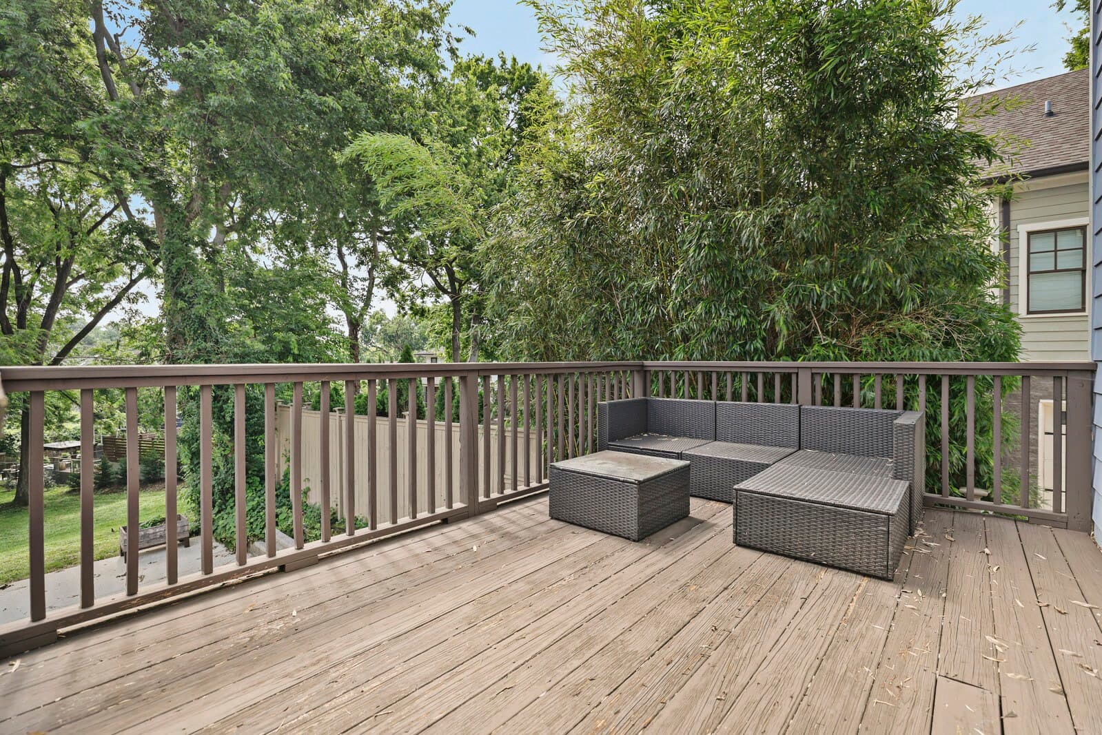 Back deck with outdoor seating looking over mature trees at 2500B 9th Ave S in 12 South Nashville