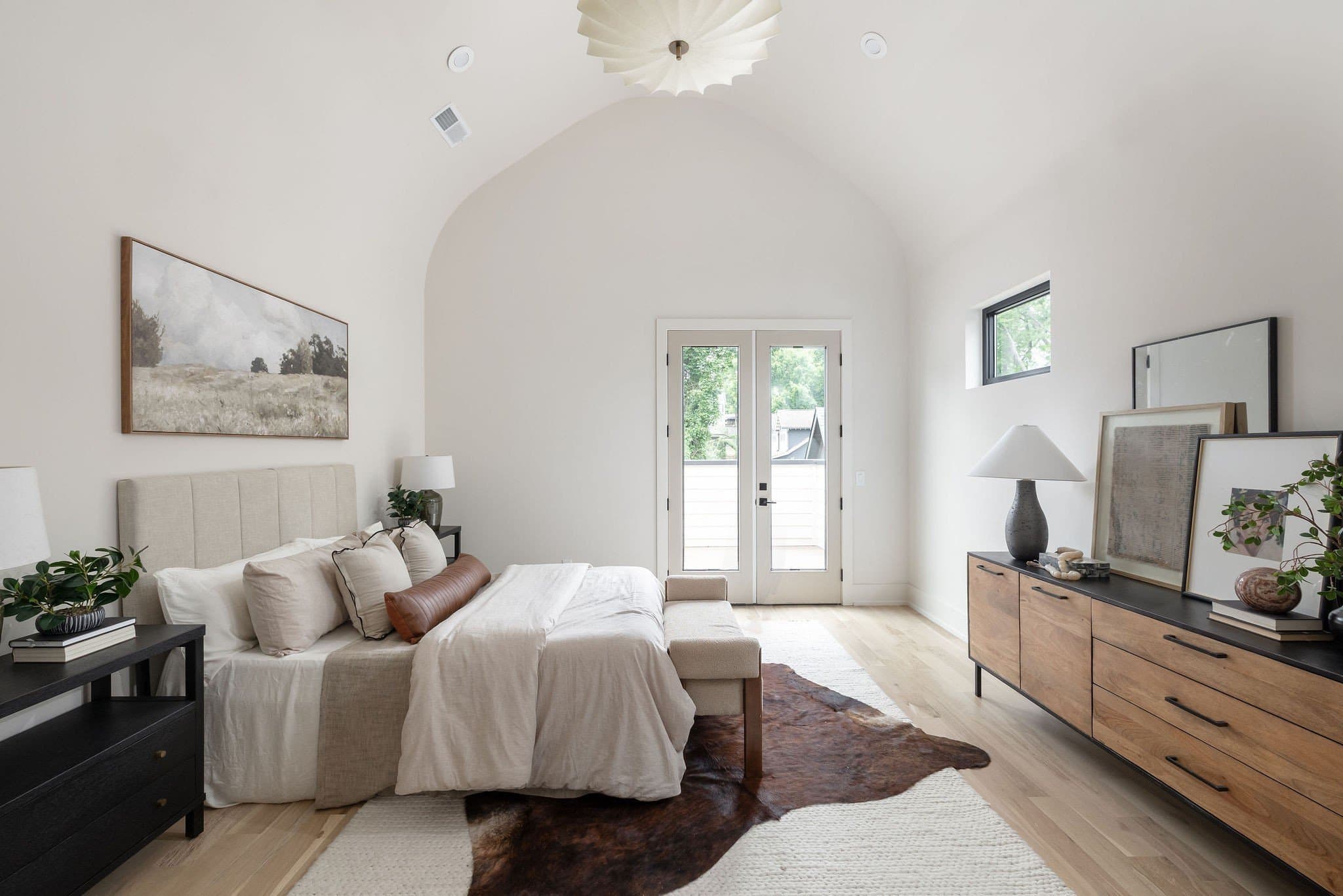 Upstairs primary bedroom with a barreled ceiling, a large pendant light, and French doors to a private porch at 2507A Vaulx Lane in 12 South Nashville