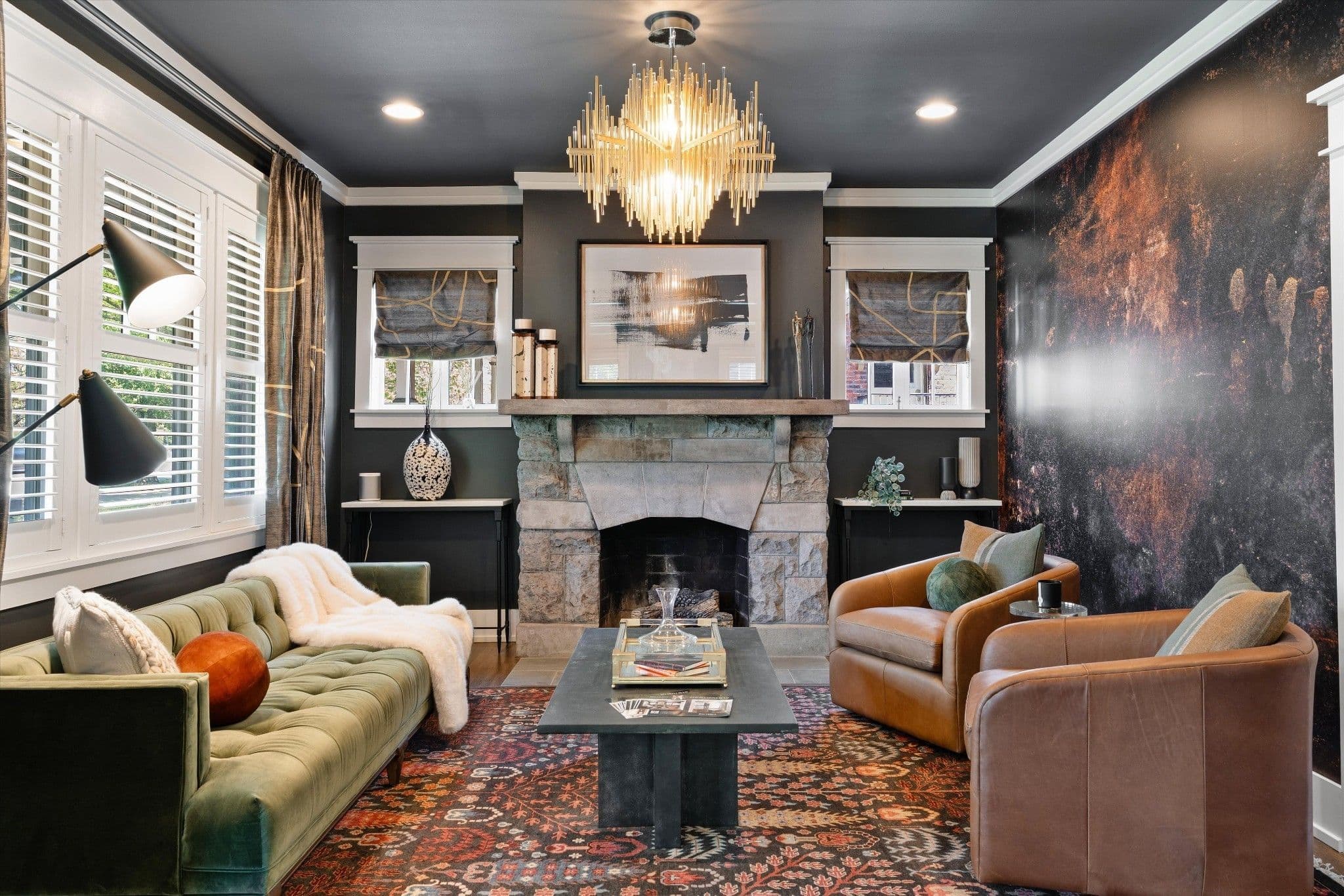 Living room with a stone fireplace, a sculptural chandelier and plantation shutters at 2510 Belmont Boulevard in 12 South Nashville