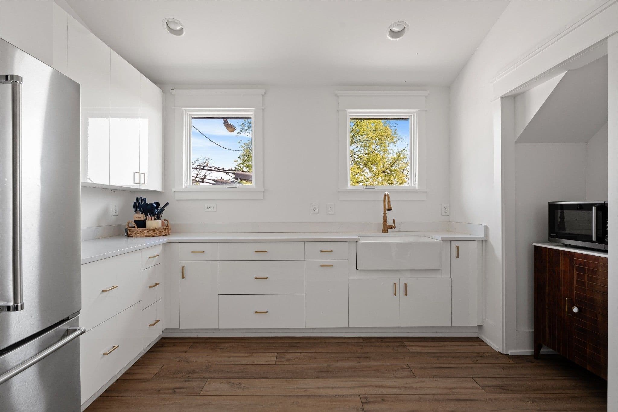 Guest apartment kitchen with white cabinets, an apron front sink and two windows at 2510 Belmont Boulevard in 12 South Nashville