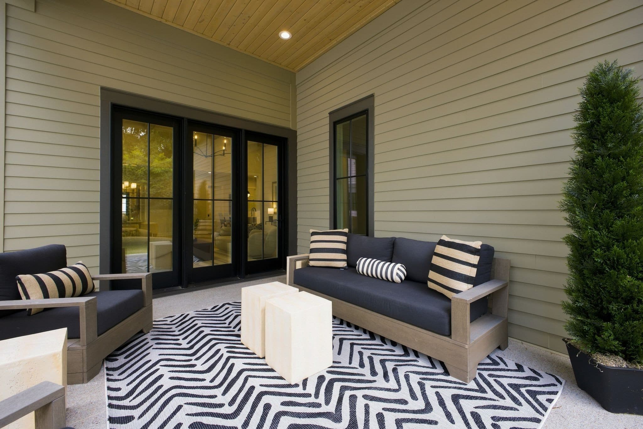 Covered back porch with seating and a wood ceiling at 2913 Vaulx Ln in 12 South Nashville