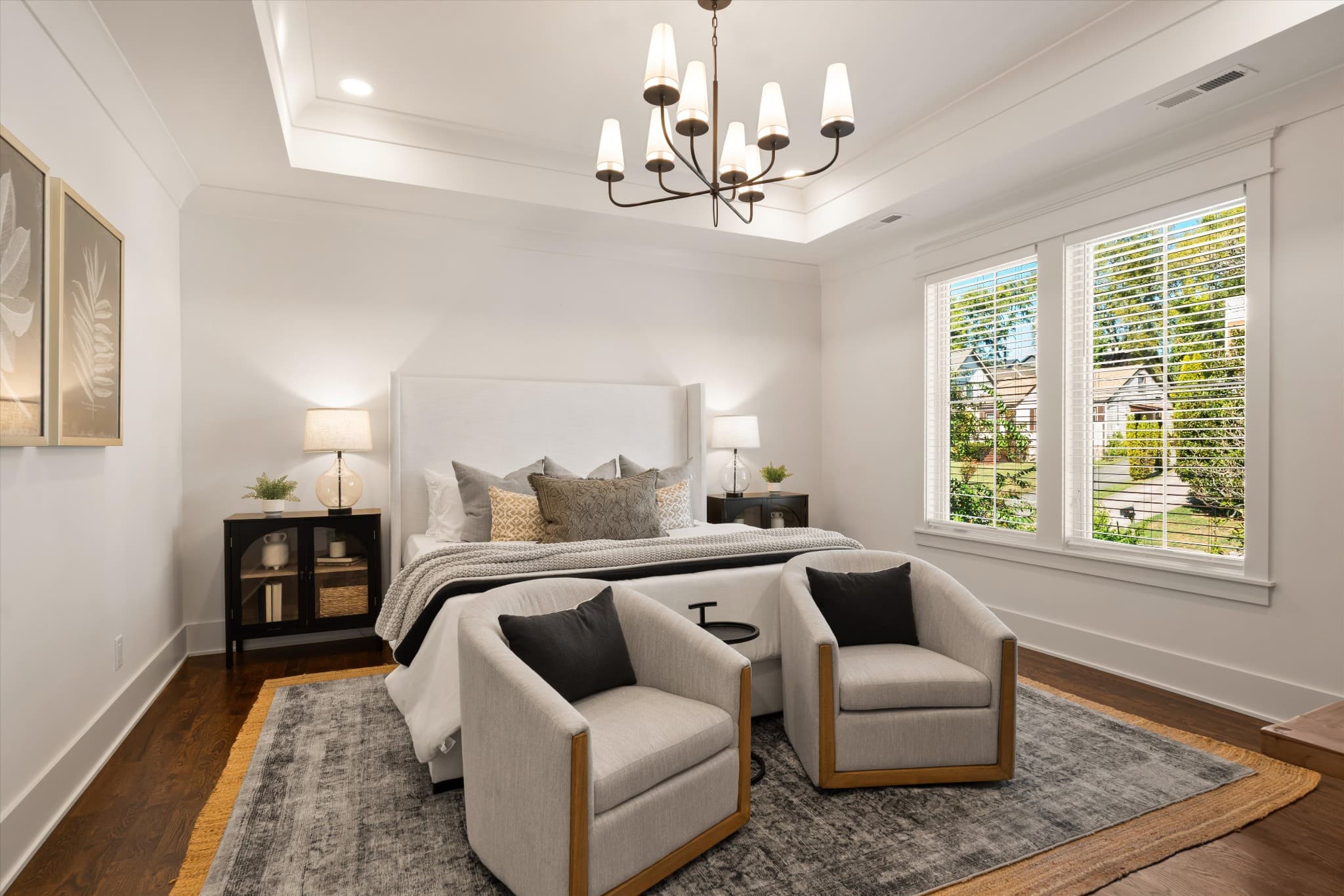 Upstairs primary bedroom with a tray ceiling, chandelier, and sitting area at 817 Horner Ave in 12 South Nashville