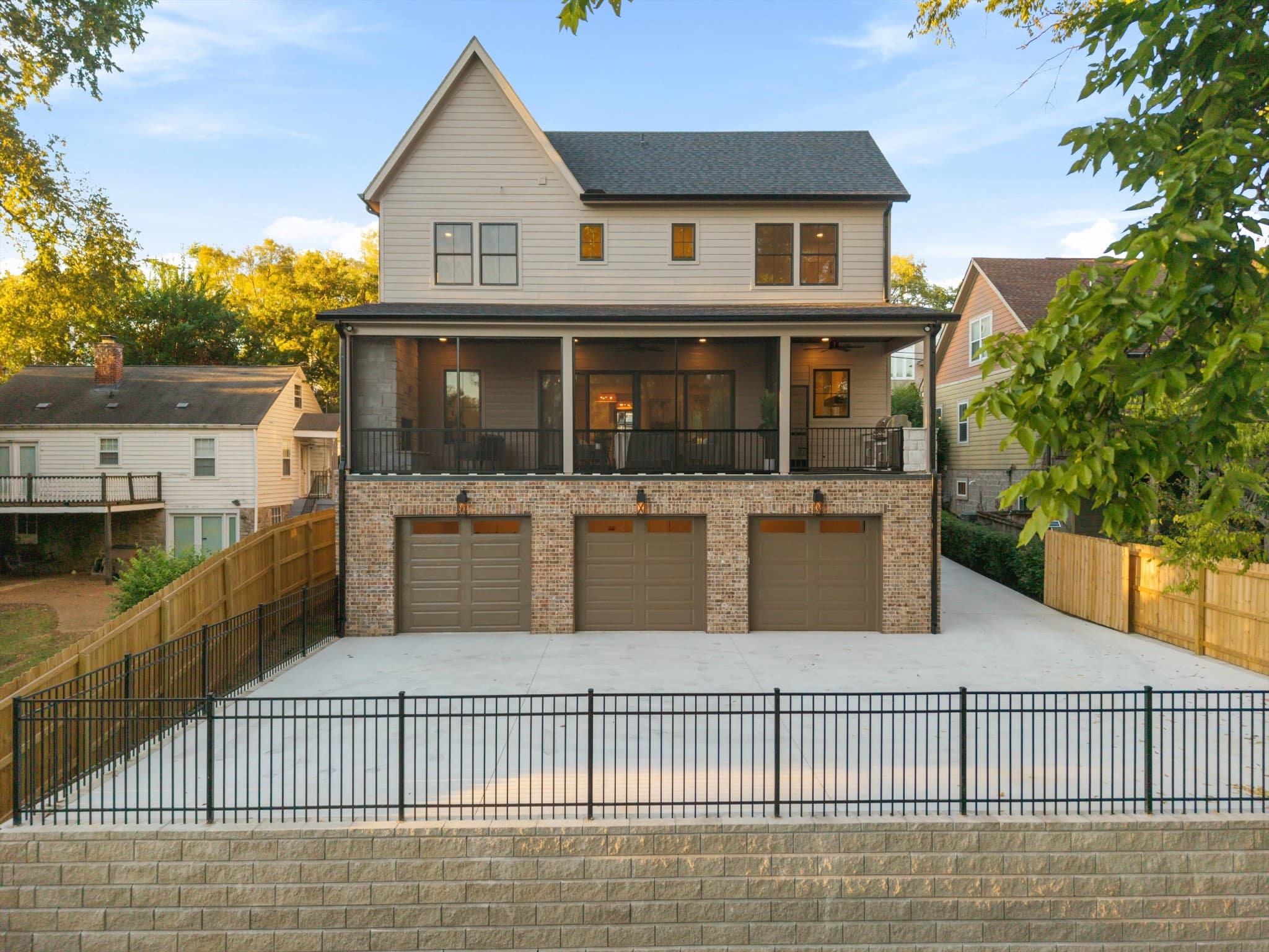 Rear exterior of 817 Horner Ave with the attached three car garage, covered porch, and fenced back yard in 12 South Nashville