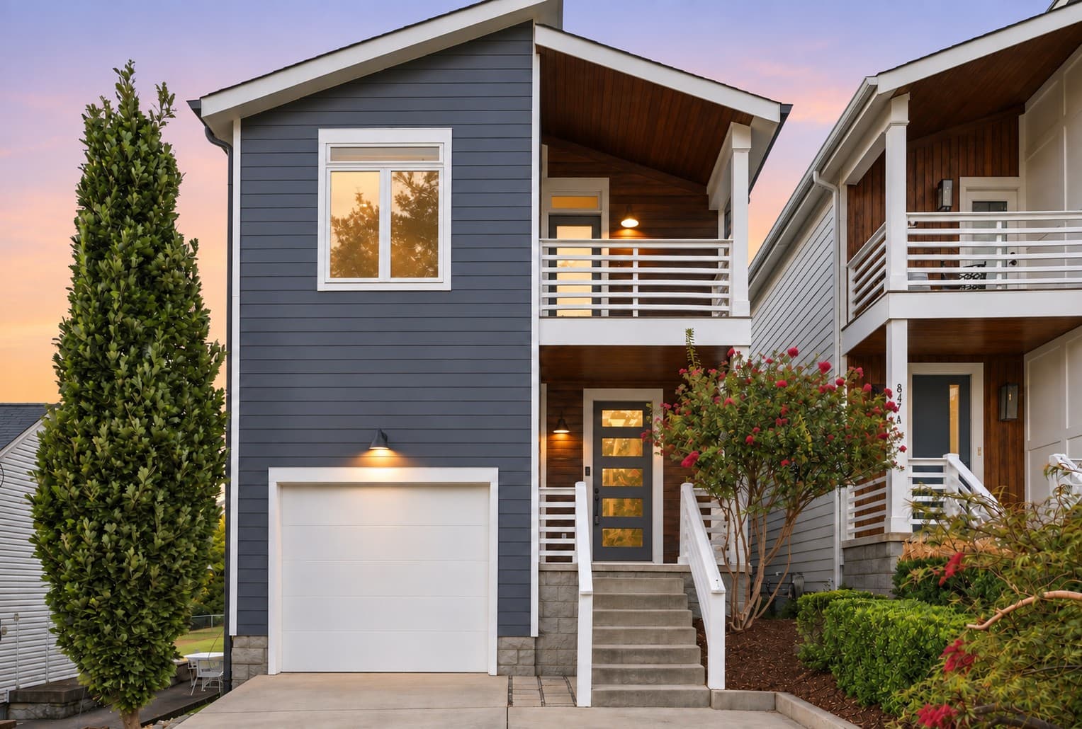 Front exterior of 847B Dewees Avenue at dusk with navy siding, front steps and a one car garage, one of the 12 South homes for sale in Nashville