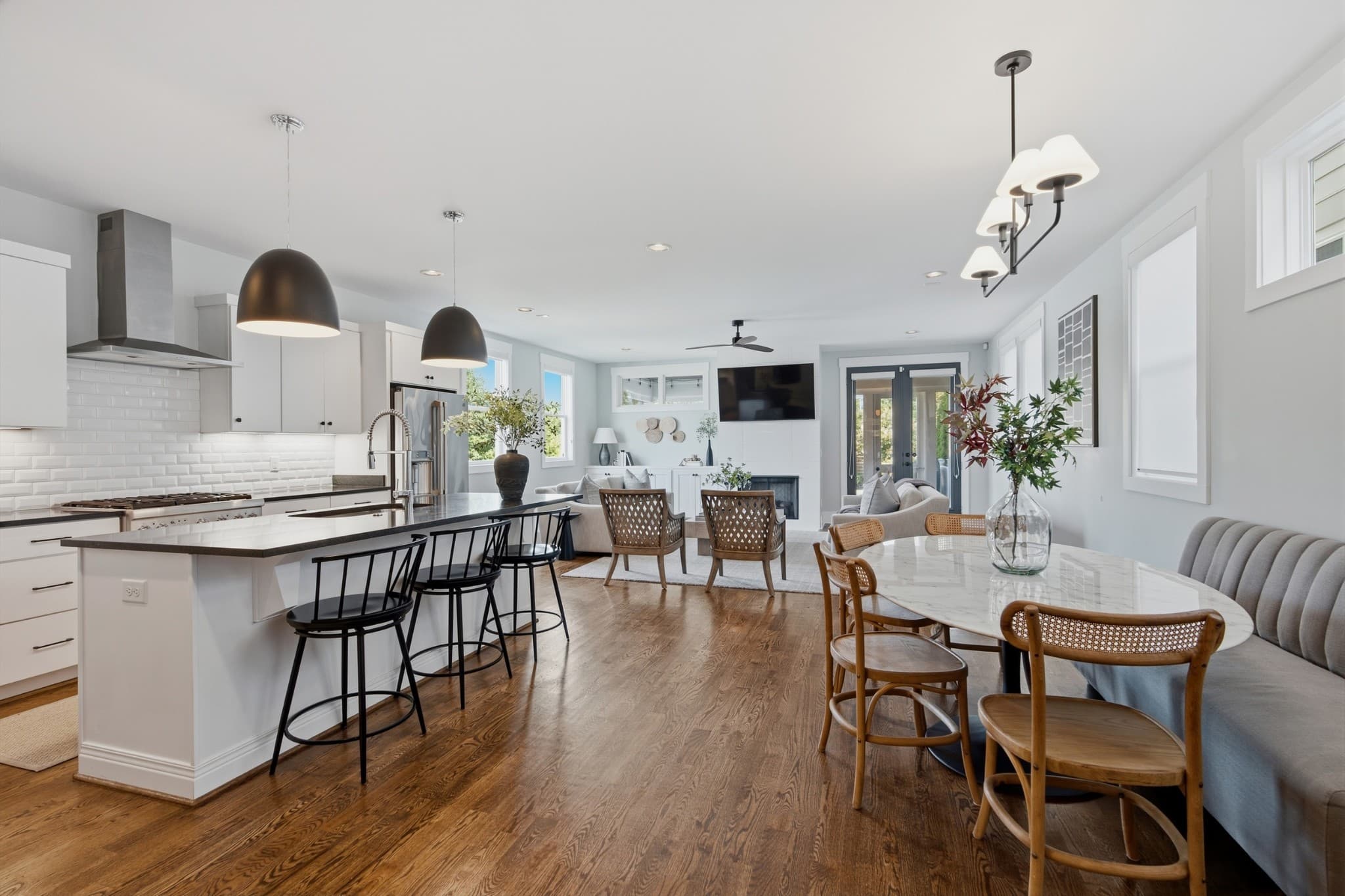 Open kitchen with island, bar stools, pendant lights and dining area at 847B Dewees Avenue in 12 South Nashville