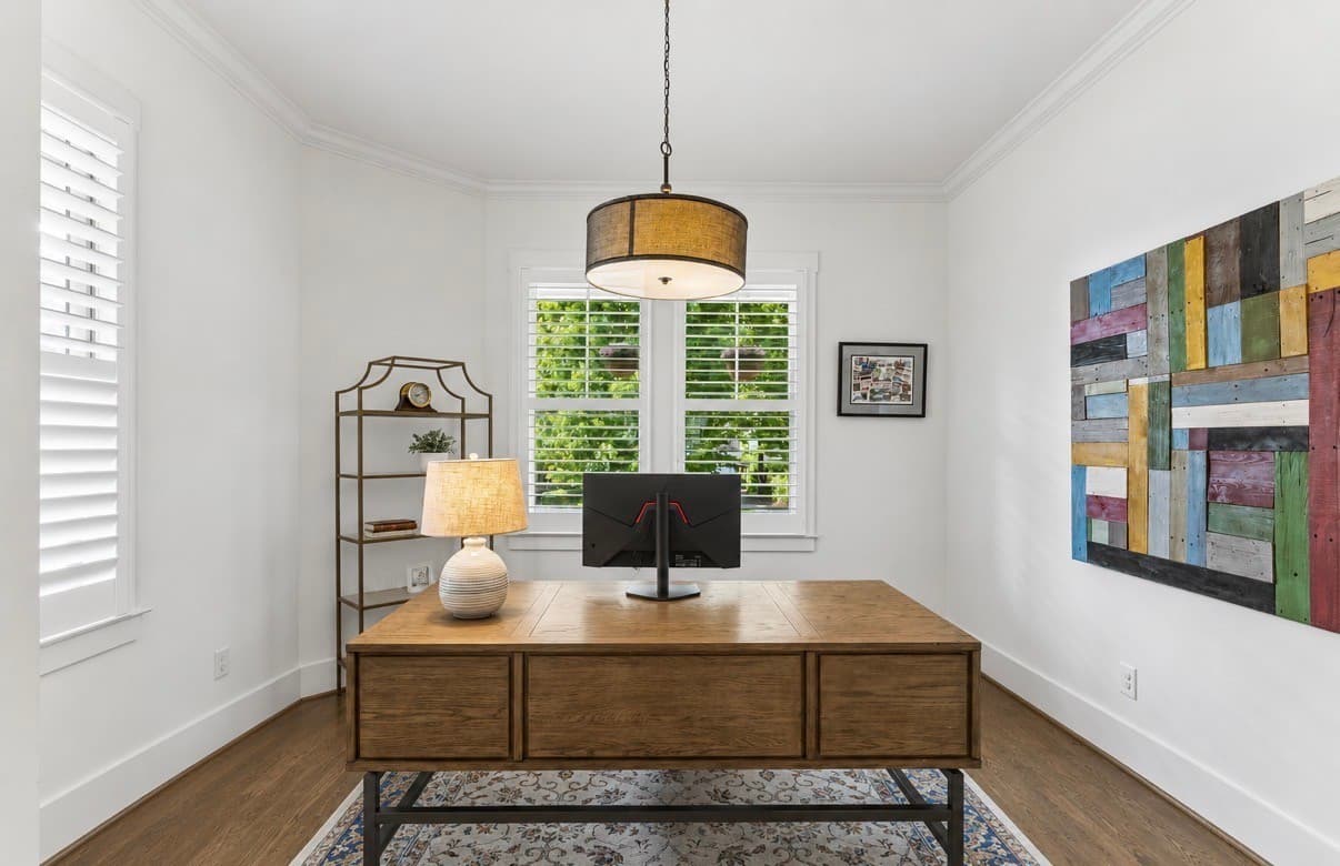 Home office with a wood desk, a pendant light and a window with shutters at 916 Montrose Avenue #A in 12 South Nashville