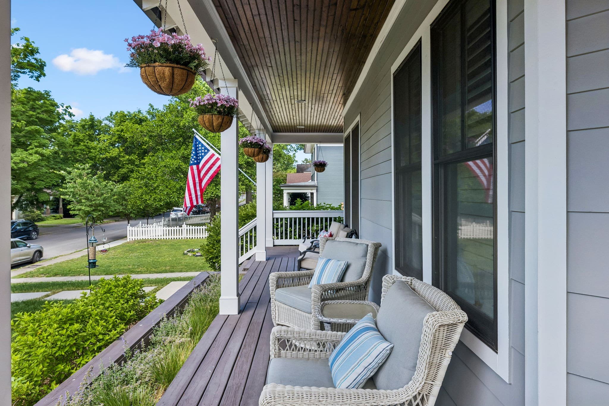 Covered front porch with wicker seating, hanging plants and a view of the street at 916 Montrose Avenue #A in 12 South Nashville