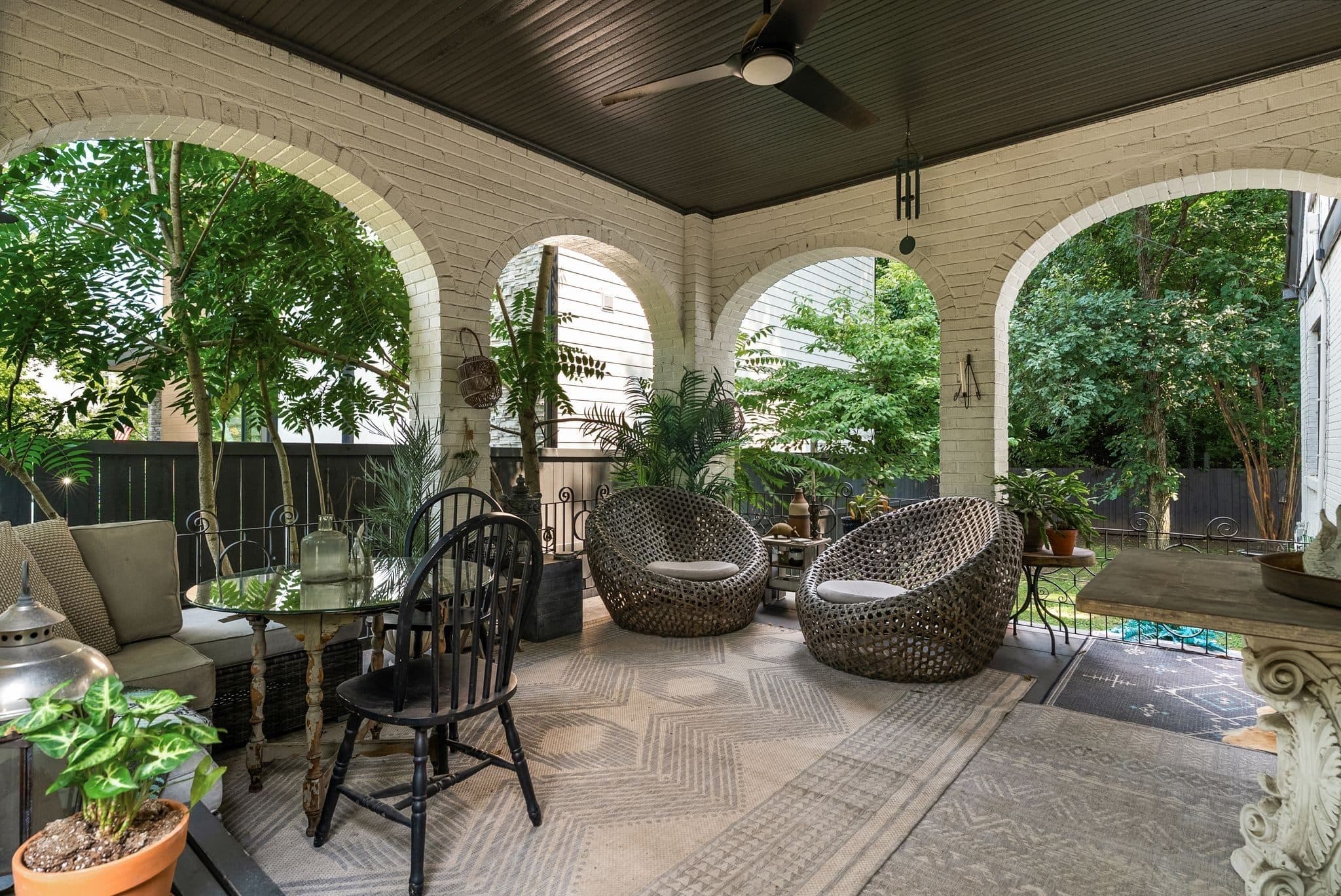 Covered porch with brick arches, a ceiling fan and outdoor seating at 947 Gale Lane in 12 South Nashville