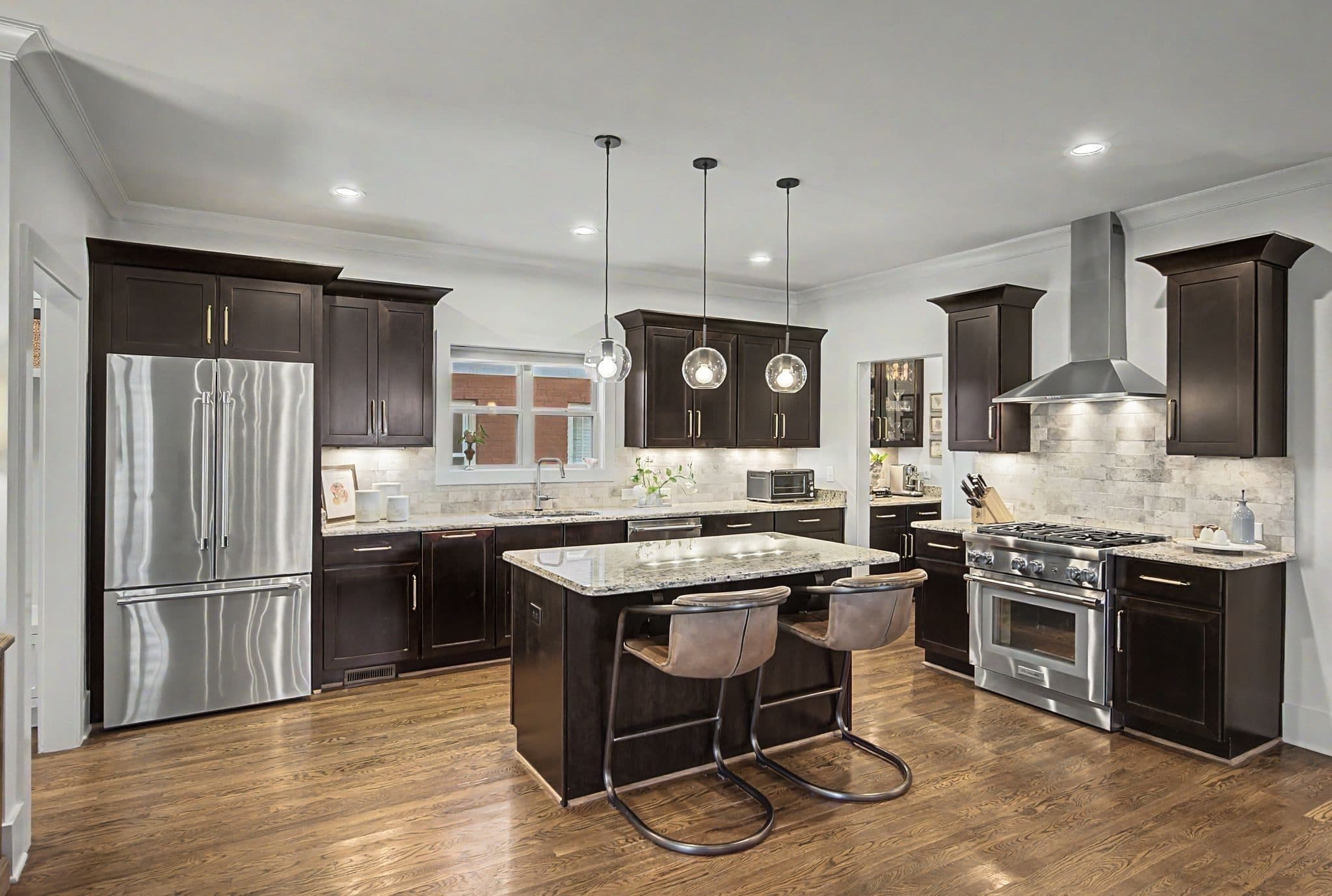 Kitchen with dark cabinets, a large island, and globe pendants at 1012 Acklen Avenue, 12 South Nashville