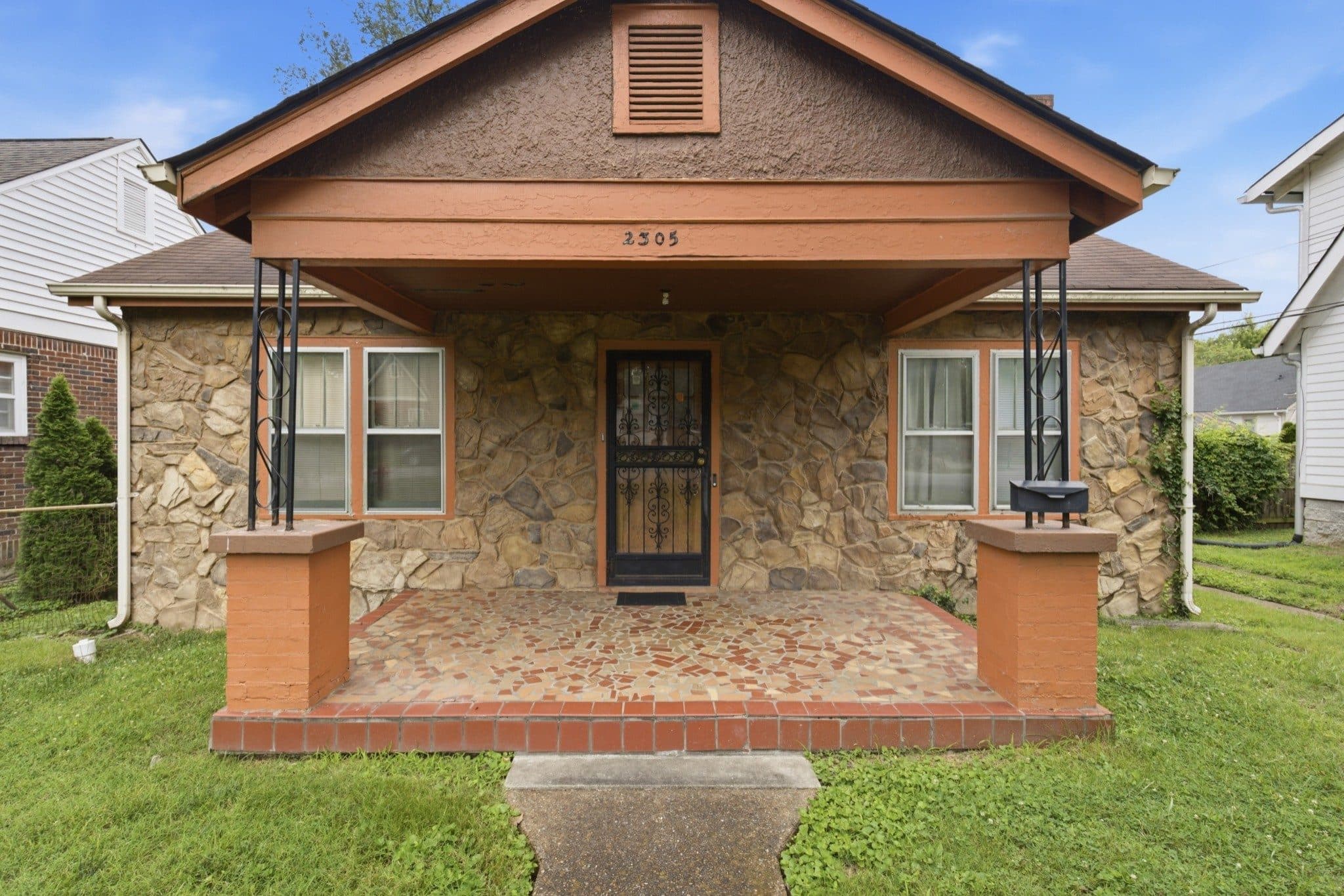Front exterior of the stone cottage with a covered porch at 2305 Cisco Street, one of the 12 South homes for sale in 12 South Nashville