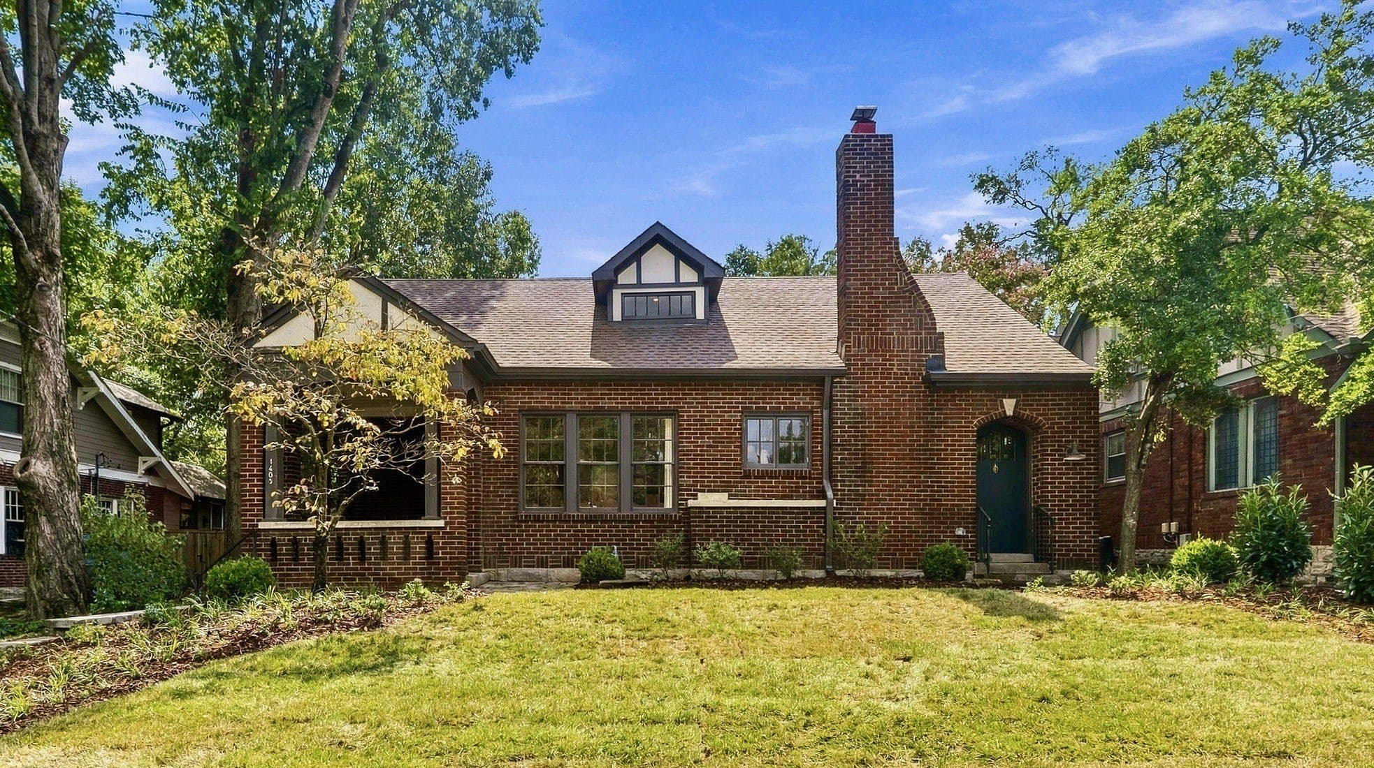 Front exterior of the brick cottage with a dormer and chimney at 1405 Clayton Avenue, one of the 12 South homes for sale in 12 South Nashville