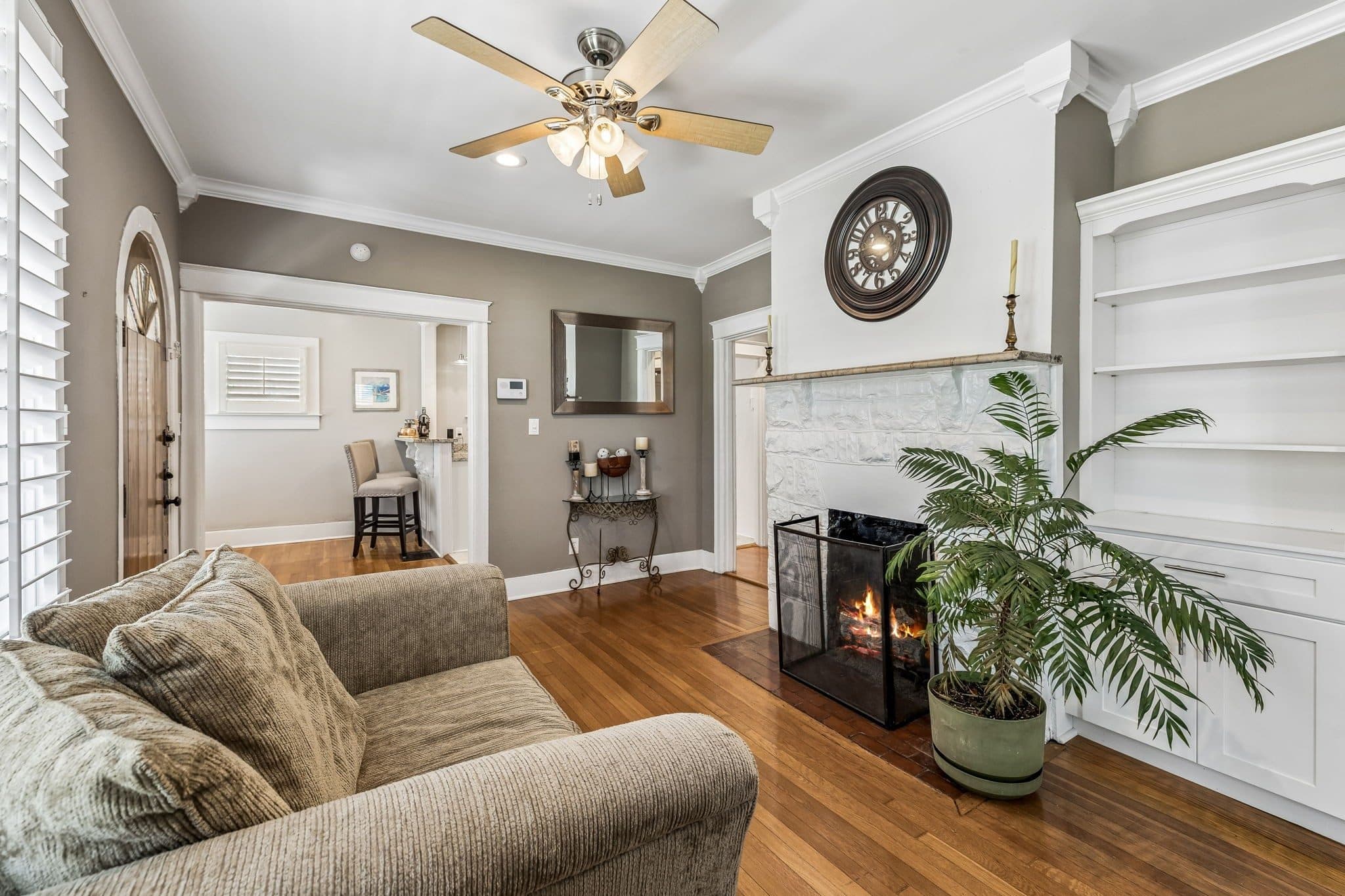Living room with a painted stone fireplace, built-in shelves, and hardwood floors at 2112 Eastwood Avenue, 12 South Nashville