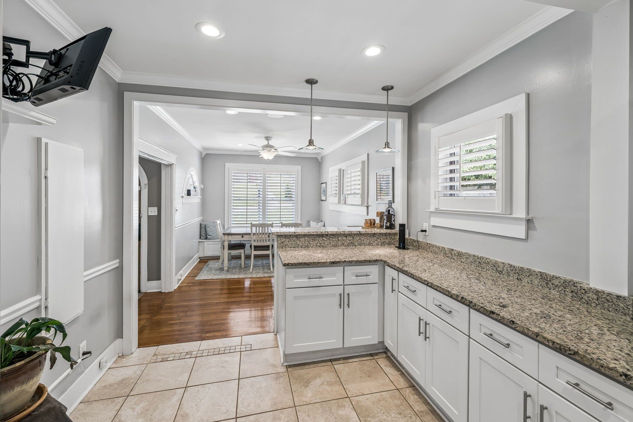 Kitchen with white cabinets, granite counters, and a view to the dining area at 2112 Eastwood Avenue, 12 South Nashville