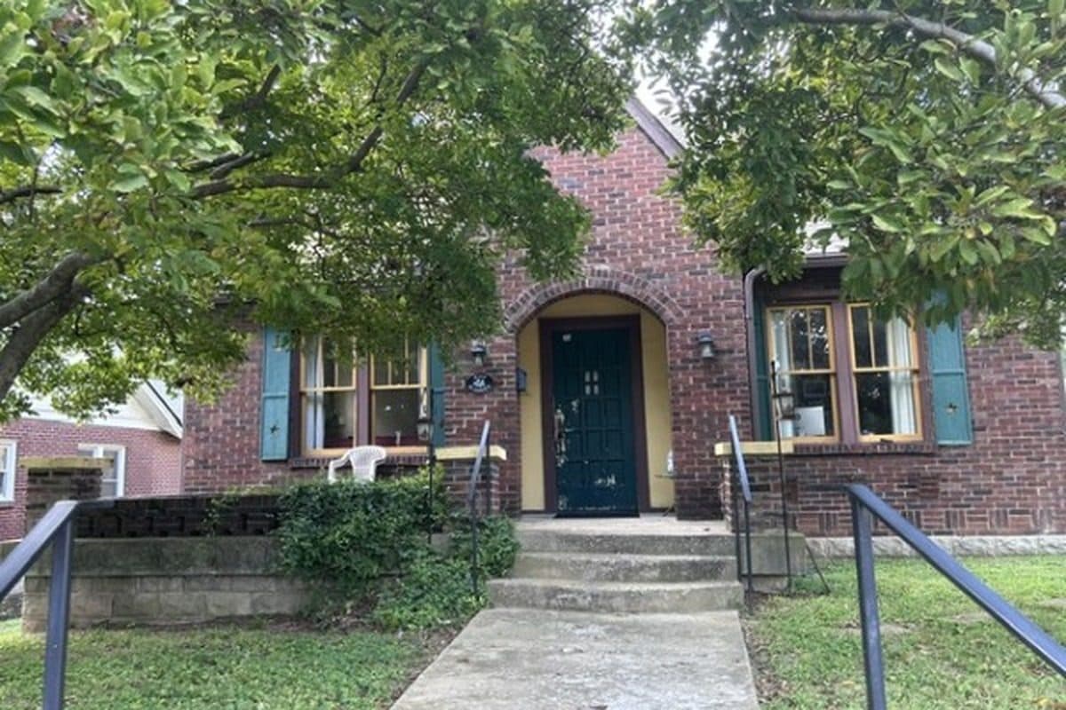 Front exterior of the brick Tudor with an arched entry at 2207 Elliott Avenue, one of the 12 South homes for sale in 12 South Nashville