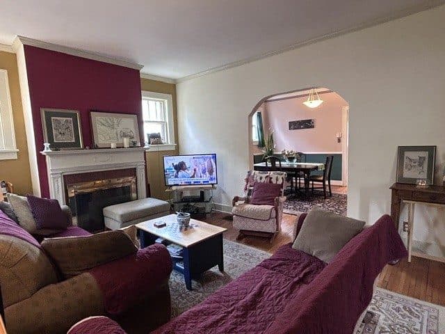 Living room with a wood-burning fireplace and an arched opening to the dining room at 2207 Elliott Avenue, 12 South Nashville