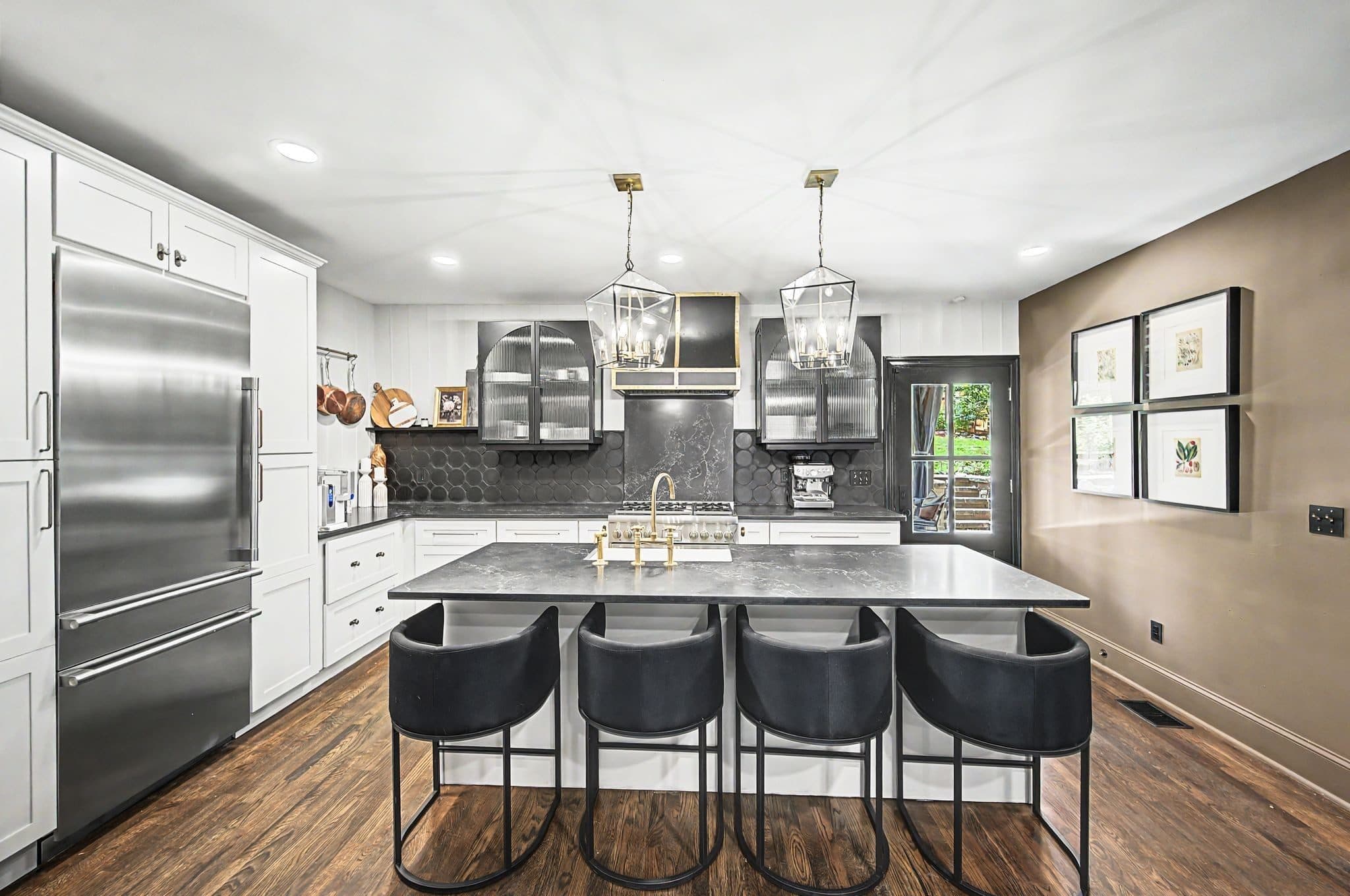 Renovated kitchen with white cabinets and a large island with seating at 837 Glen Avenue, 12 South Nashville