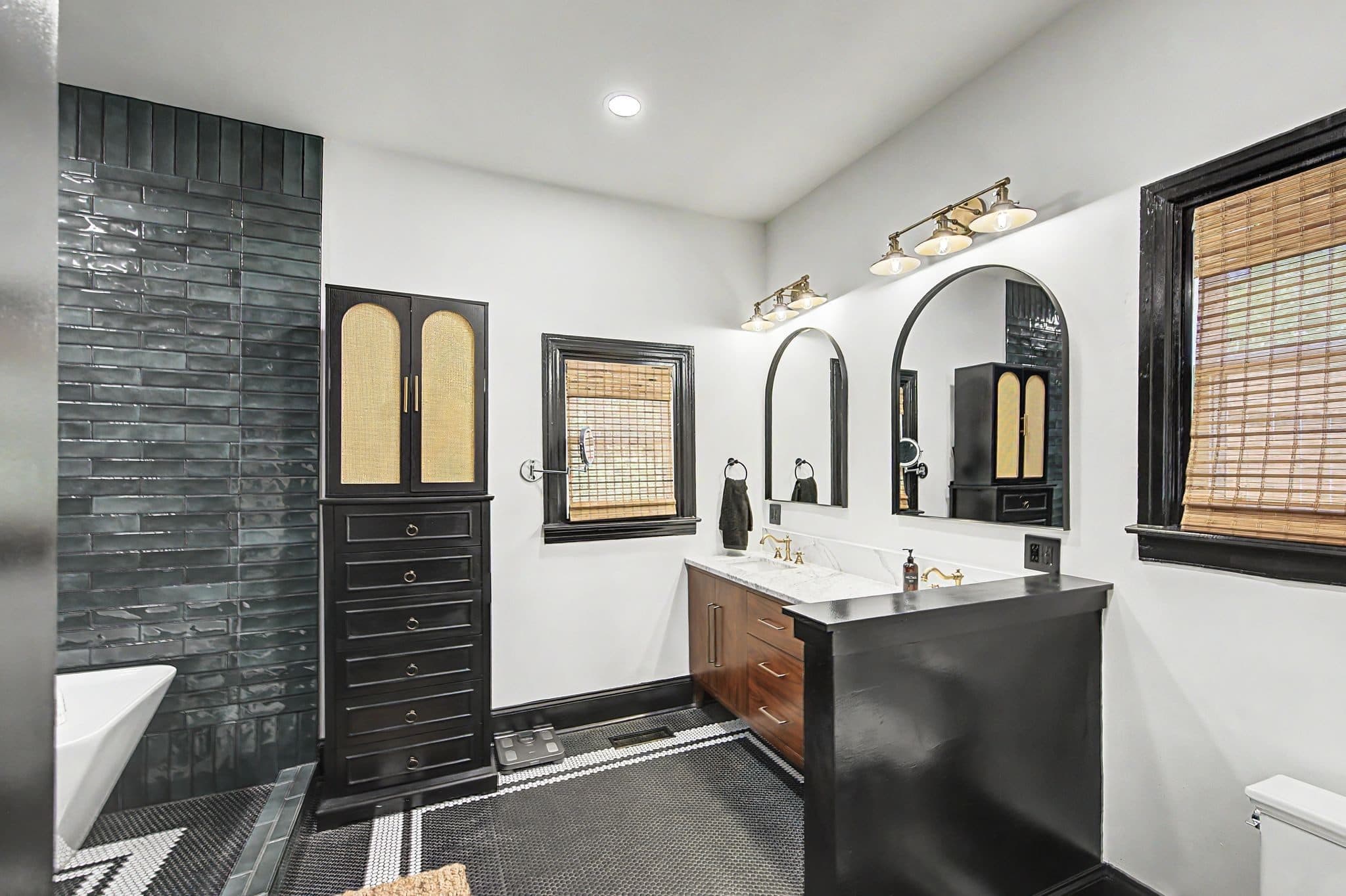 Renovated primary bath with a freestanding tub, dark tile wall, and arched mirrors at 837 Glen Avenue, 12 South Nashville