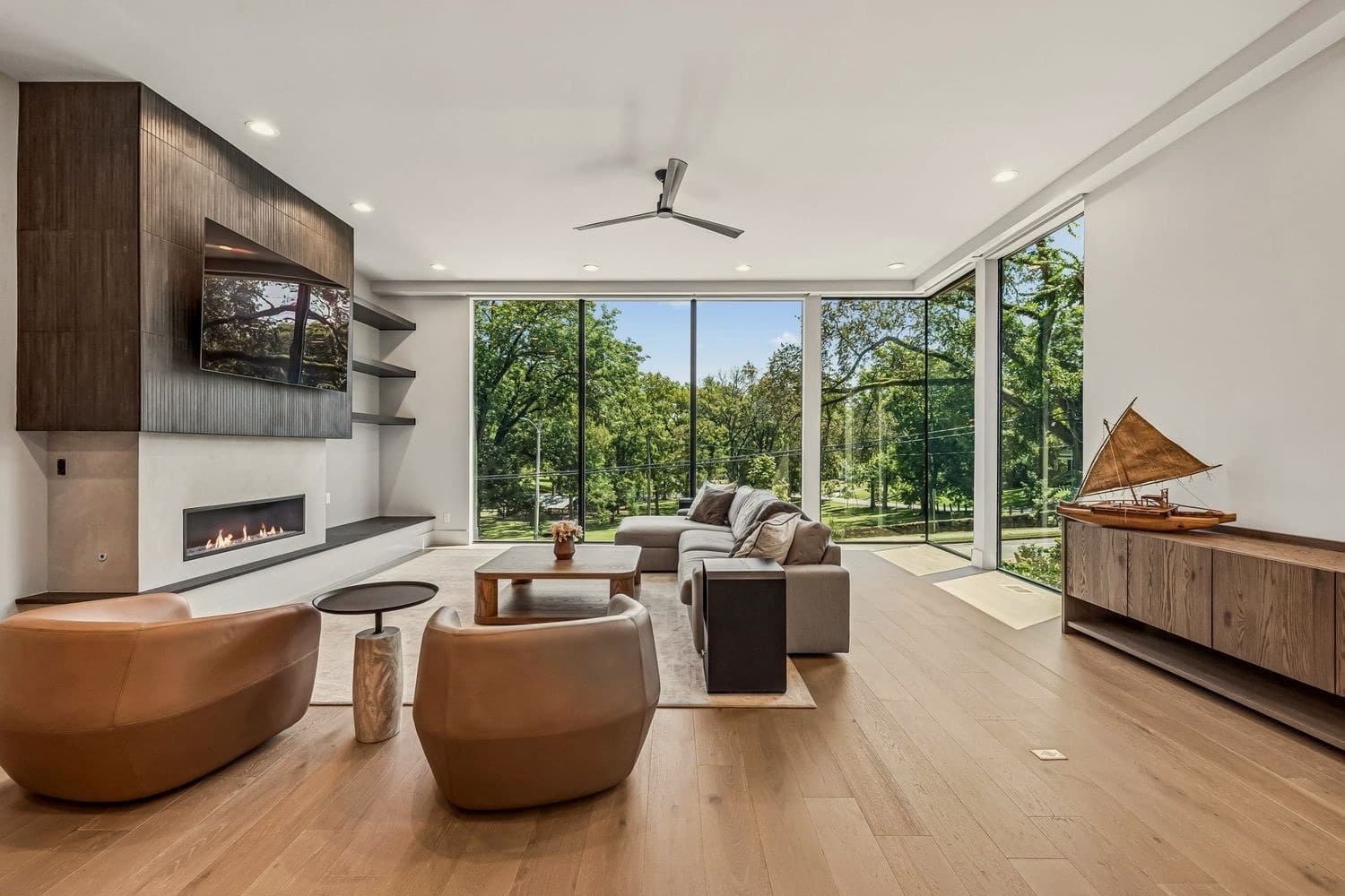 Living room with linear fireplace and floor to ceiling windows facing the trees of Sevier Park at 3205B Granny White Pike, 12 South Nashville