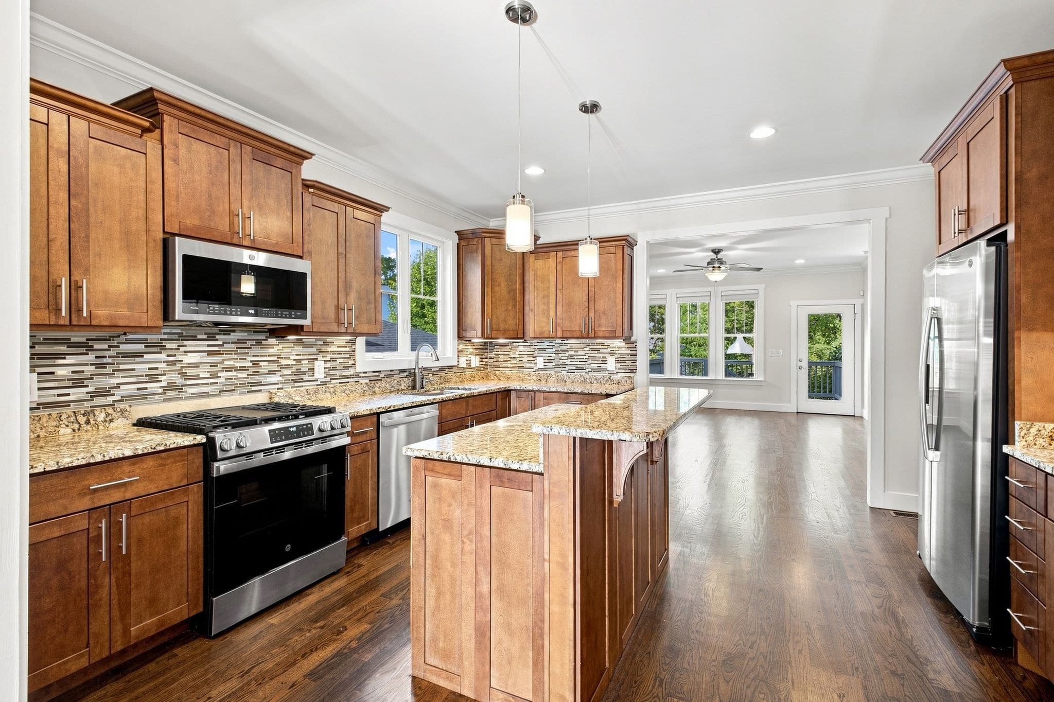Kitchen with wood cabinetry, island, stone counters, and stainless appliances at 2822 W Kirkwood Avenue, 12 South Nashville