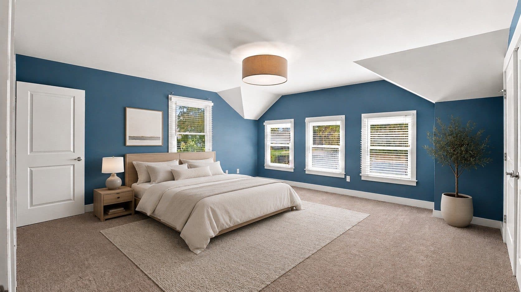 Primary bedroom with a blue accent wall and three windows at 2950 Vaulx Lane, 12 South Nashville